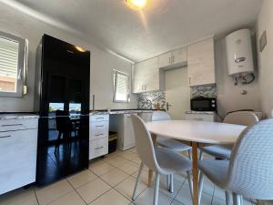 a kitchen with a table and chairs in a room at Apartments Kovač in Vir