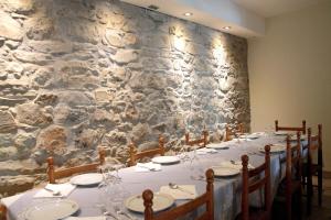 a long table in a room with a stone wall at Locanda Il Gigante in Collagna