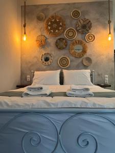 a bedroom with a large bed with plates on it at Anemologio Fine Village Living in Ayía Kiriakí