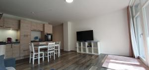 マイニンゲンにあるCharmante Ferienwohnung 2 im Herzen von Meiningenのテーブルとテレビのあるキッチンとダイニングルーム