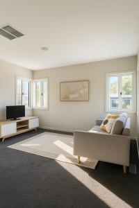 a living room with a couch and a tv at Yarra Valley Retreat - Kids, Wine, Outdoors in Healesville