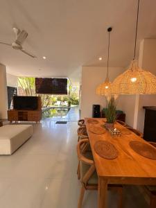 塞米亚克NEW Villa Indah Seminyak 3BR Private Pool的配有木桌和沙发的餐厅