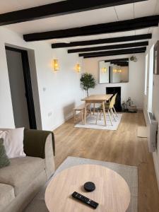 ein Wohnzimmer mit Sofa und Tisch in der Unterkunft New renovated beach front cottage in Mousehole