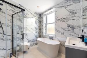 Un baño con bañera, lavabo y ducha. en Kew Garden Suite 2BR Sleeps 9 Near Central London, en Richmond upon Thames 27 fotos más