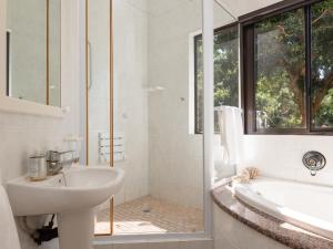 a white bathroom with a sink and a bath tub at Ihlati 3, Zimbali Estate by Euphoric Leisure in Ballito +24 photos