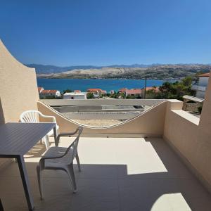 a balcony with a table and chairs and a view of the water at Sun Anna Apartments in Pag
