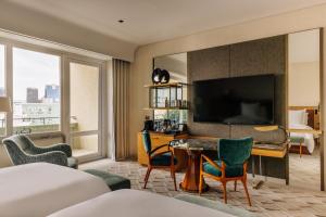 a hotel room with a bed and a desk with a television at Four Seasons Hotel Ritz Lisbon in Lisbon