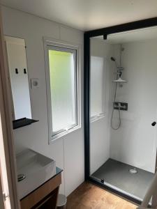 a bathroom with a mirror and a sink and a window at Mobil home neuf à étaples à 5 minutes du touquet in Étaples +5 photos