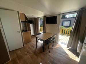 a kitchen and dining room with a table and chairs at Mobil home neuf à étaples à 5 minutes du touquet in Étaples +4 photos