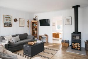 a living room with a couch and a wood stove at Shack In The Dunes in Weymouth