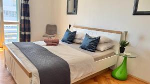 ein Schlafzimmer mit einem Bett mit blauen Kissen und einem Stuhl in der Unterkunft Tortosa Blue in Split