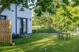 einen Garten mit einem Tisch, Stühlen und einem Zaun in der Unterkunft Solo na wyspie, blisko morza Sobieszewo in Danzig