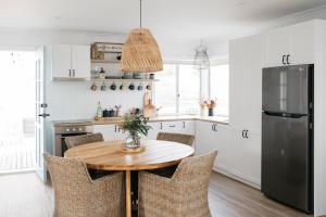 a kitchen with a wooden table and a refrigerator at Shack In The Dunes in Weymouth