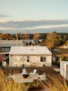 a white house with two white chairs and a table at Shack In The Dunes in Weymouth
