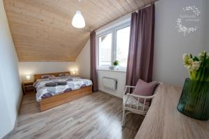 a bedroom with a bed and a window at Karłowski Przesmyk in Grabowo