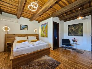 a bedroom with a large bed and a wooden ceiling at B&B Plitvica Lodge in Plitvica Selo