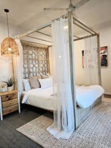 a bedroom with two beds with mosquito nets at Modern Luxe Retreat Brisbane in Doolandella