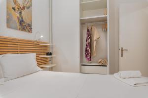 a bedroom with a white bed and a closet at The Little Loft in Pefkochori