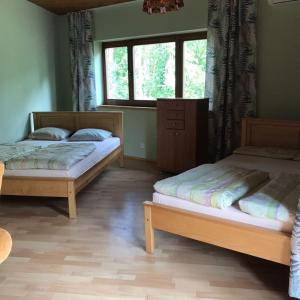 zwei Betten in einem Zimmer mit Fenster in der Unterkunft Białe Brenno in Brenno
