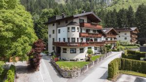 duży biały budynek na wzgórzu z drzewami w obiekcie Montana Apartments w Mayrhofen