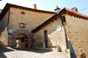 een bakstenen gebouw met een deuropening en een boog bij Hotel Rural Nobles de Navarra in Áibar