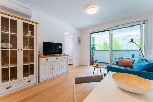 a living room with a blue couch and a tv at Flex SelfCheckIns 149 - Zagreb - Bedroom - Garage - Loggia in Zagreb
