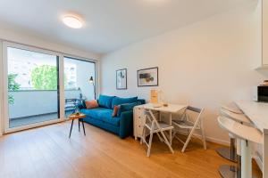 a living room with a blue couch and a table at Flex SelfCheckIns 149 - Zagreb - Bedroom - Garage - Loggia in Zagreb +31 photos