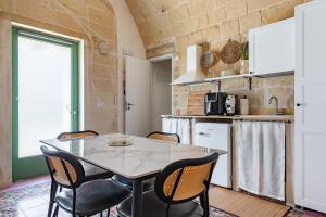 a kitchen and dining room with a table and chairs at Palazzo Borgomonte - holiday home in Otranto +28 photos