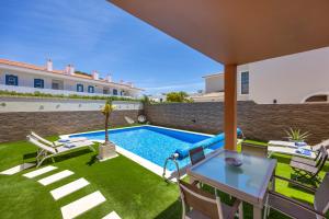 a patio with a table and chairs and a swimming pool at Casa Sunrise in Lagos
