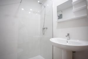 a white bathroom with a sink and a shower at LETS HOLIDAYS Centric & Near the Sea Victoria apartment 3 in Tossa de Mar +9 photos