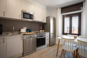 a kitchen with stainless steel appliances and a table at LETS HOLIDAYS Centric & Near the Sea Victoria apartment 3 in Tossa de Mar