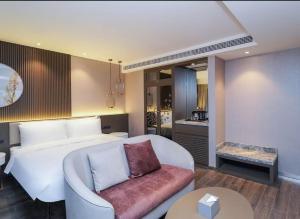 a bedroom with a bed and a couch and a table at Crystal Orange Shanghai Lingang Ocean Park Hotel in Nianbalian