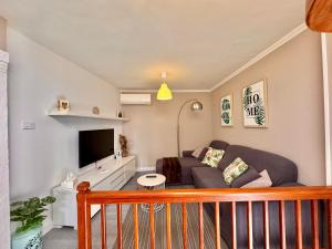 a living room with a couch and a tv at Casa A Codela in Combarro