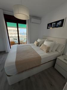 a large white bed in a room with a window at Apartamentos Roquetas Beach in Roquetas de Mar +52 photos