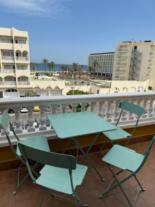 a green table and two chairs on a balcony at Apartamentos Roquetas Beach in Roquetas de Mar