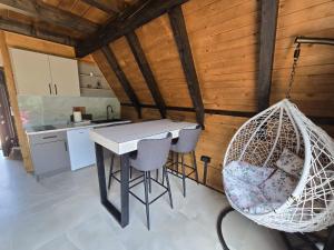 a kitchen with a table and chairs and a swing at JAGI Bungalovi Mrkonjic Grad in Mrkonjić Grad