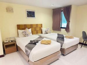 two beds in a hotel room with at Bensri residence pattaya in Pattaya South