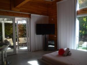 a bedroom with a bed with a flat screen tv at אננדו in ‘En Sarid