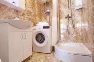 a bathroom with a washing machine and a toilet at Olea House in Lukoran
