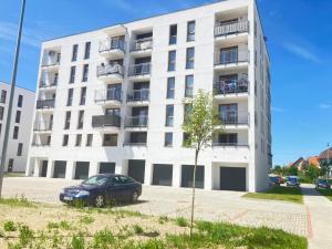 a car parked in front of a white building at Apartament Jan in Szczytno