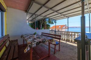 a table and bench on a balcony with a view of the water at Apartment Irmica in Lukovo Šugarje