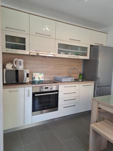 een keuken met witte kasten en een kookplaat oven bij Beach apartment in Mandre in Mandre