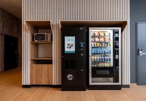 a soda machine in a room with a refrigerator at B&B HOTEL Valenciennes Onnaing 3 étoiles Parc d Activités de la Vallée de l Escaut in Onnaing