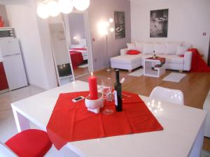 un soggiorno con tavolo bianco e tovagliolo rosso di Apartments Cvek a Rovigno (Rovinj)