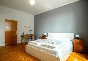 a bedroom with a large white bed with white sheets at Apartment Residenz in Klagenfurt