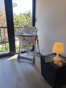 een stoel en een lamp in een kamer met een raam bij Beach apartment in Mandre in Mandre +19 foto's