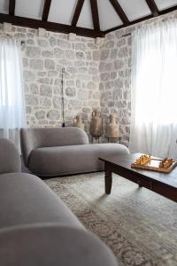 a living room with two couches and a stone wall at Heritage house Stone Orchard, near Dubrovnik in Orasac