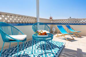 two chairs and a table with a bowl of fruit on a balcony at Palazzo Borgomonte - holiday home in Otranto