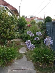 een tuin met paarse bloemen en een blauw hek bij Maison de vacances très agréable LA BAULE in La Baule