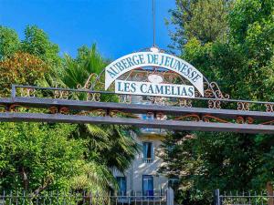 un cartel delante de un edificio con árboles en Auberge de Jeunesse HI Nice Les Camélias, en Niza